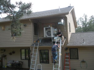 A man climbing up the ladder to help fix the HVAC system